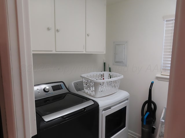 washroom with cabinet space, washer and dryer, and electric panel
