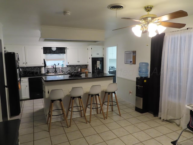 kitchen featuring black appliances, dark countertops, a ceiling fan, white cabinetry, and tasteful backsplash