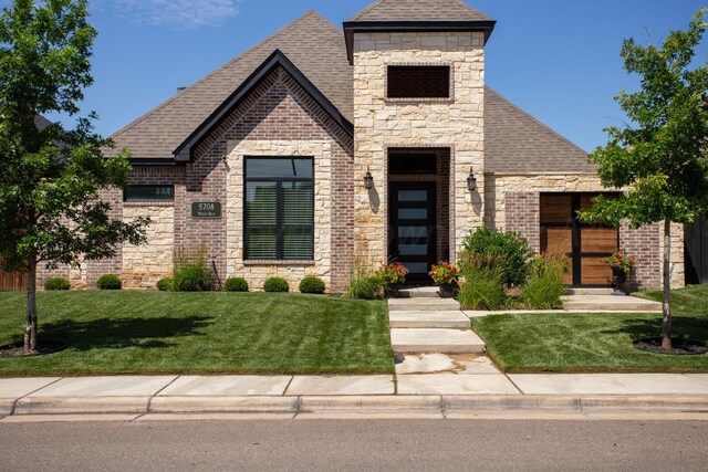 5708 Wesley Rd, Amarillo, TX 79119 - french country inspired facade with a shingled roof, a front lawn, and brick siding