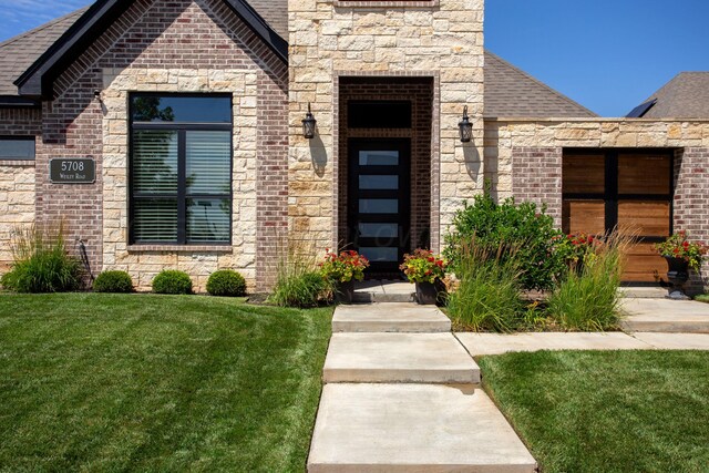 5708 Wesley Rd, Amarillo, TX 79119 - entrance to property featuring a lawn, brick siding, a shingled roof, and stone siding