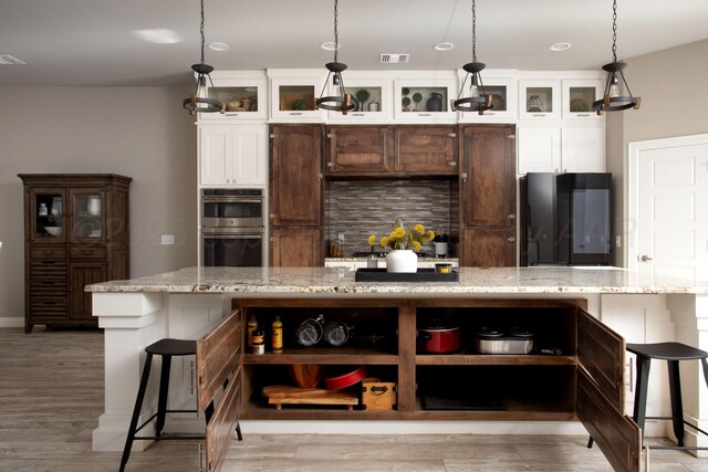 5708 Wesley Rd, Amarillo, TX 79119 - kitchen with fridge, stainless steel double oven, decorative backsplash, a center island, and a breakfast bar