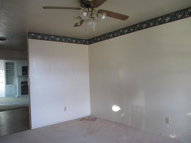 carpeted spare room featuring ceiling fan