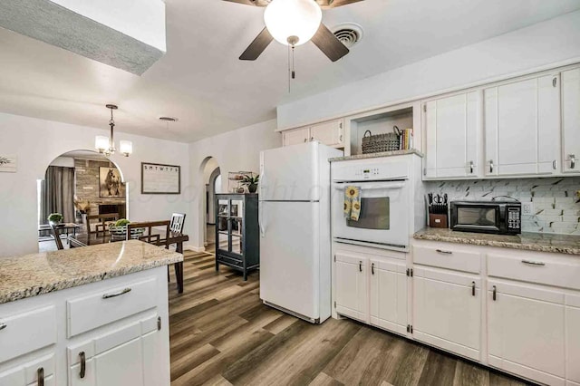 kitchen featuring hanging light fixtures, white cabinetry, white appliances, dark hardwood / wood-style floors, and decorative backsplash