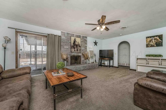 carpeted living room with a fireplace and ceiling fan