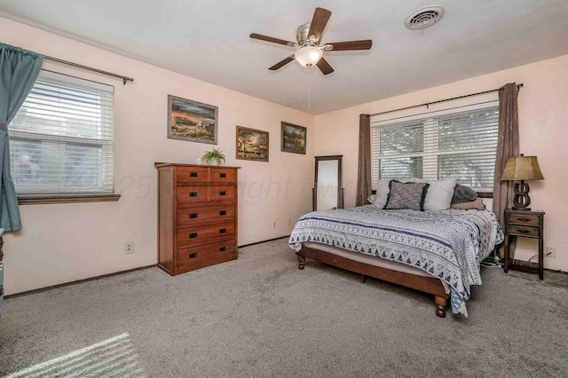 carpeted bedroom with ceiling fan and multiple windows