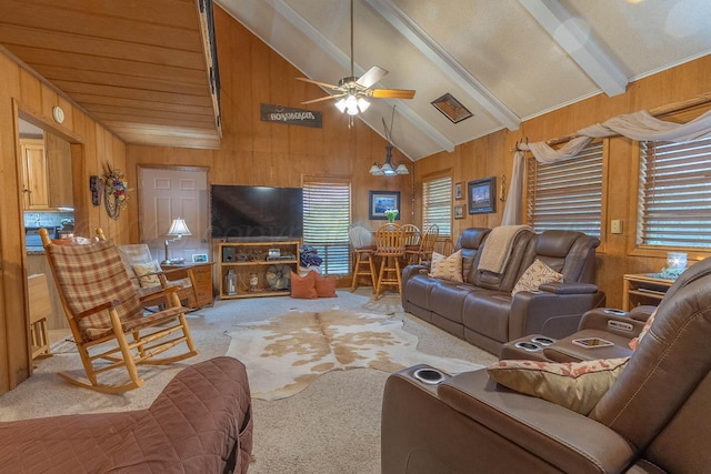 carpeted living area with wood walls, ceiling fan, and a chandelier