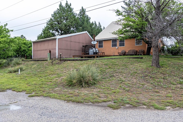 view of green lawn featuring a pole building and an outdoor structure