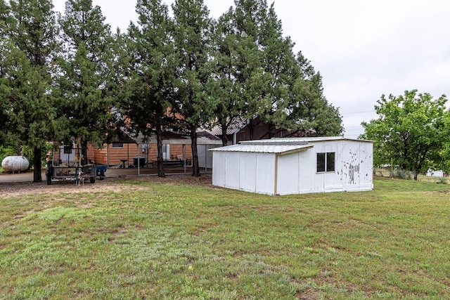 view of green lawn featuring an outbuilding
