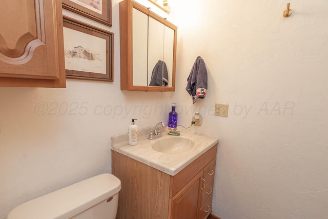 half bathroom featuring vanity and toilet