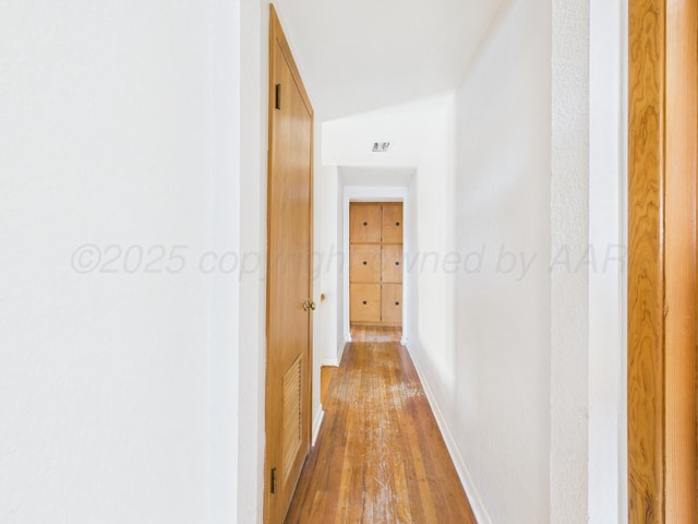 hallway featuring hardwood / wood-style floors and baseboards