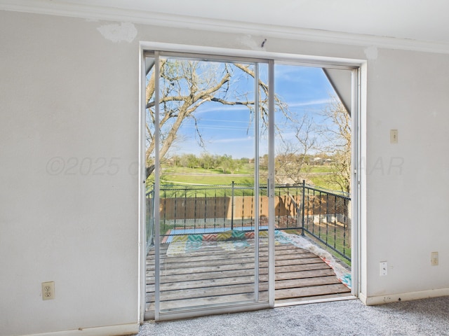 doorway to outside featuring carpet, baseboards, and ornamental molding
