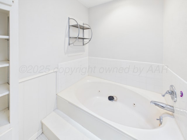 full bath featuring a jetted tub and wainscoting