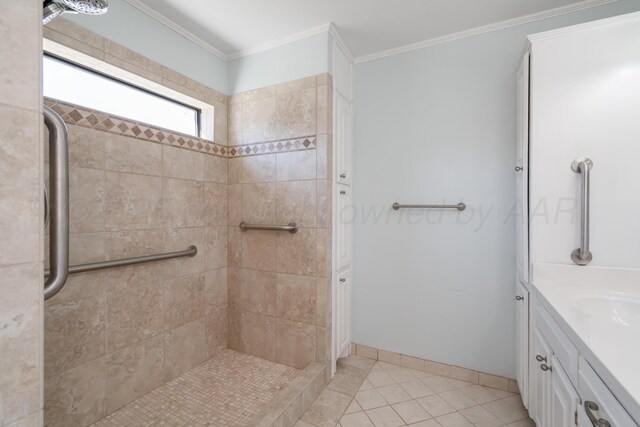 full bath featuring tile patterned floors, ornamental molding, a tile shower, baseboards, and vanity