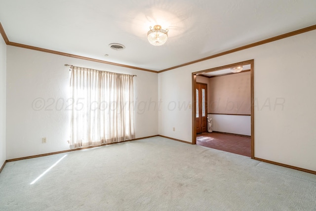 carpeted spare room featuring visible vents, baseboards, and crown molding