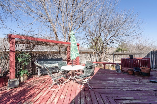 deck with outdoor dining area and a fenced backyard