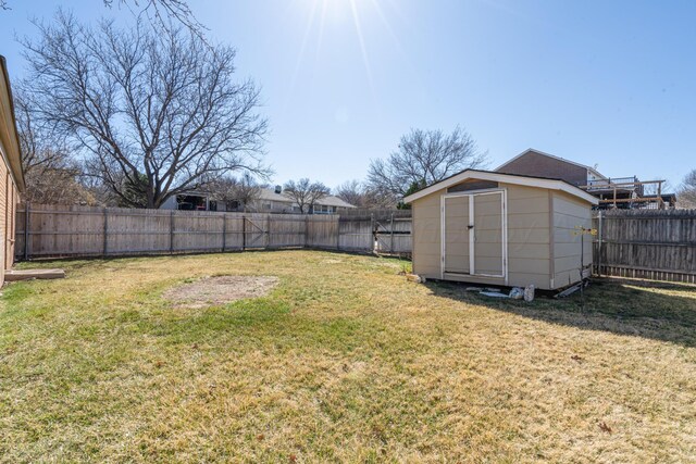 view of yard featuring an outbuilding, a fenced backyard, and a shed