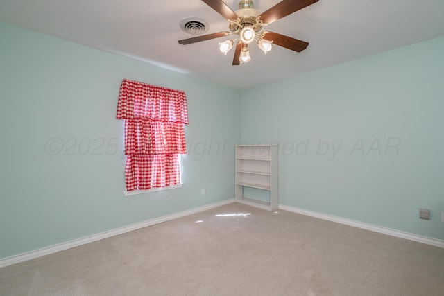 carpeted spare room featuring a ceiling fan, baseboards, and visible vents