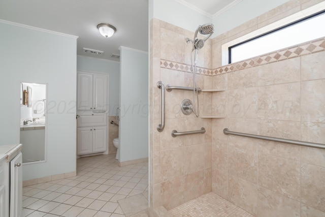 bathroom with vanity, a tile shower, and ornamental molding