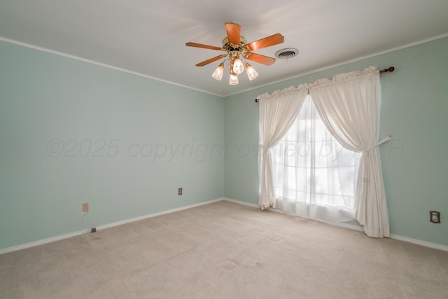 spare room with visible vents, crown molding, baseboards, ceiling fan, and light colored carpet