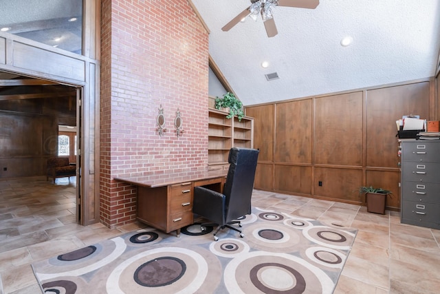 unfurnished office featuring wooden walls, visible vents, lofted ceiling, built in desk, and a textured ceiling