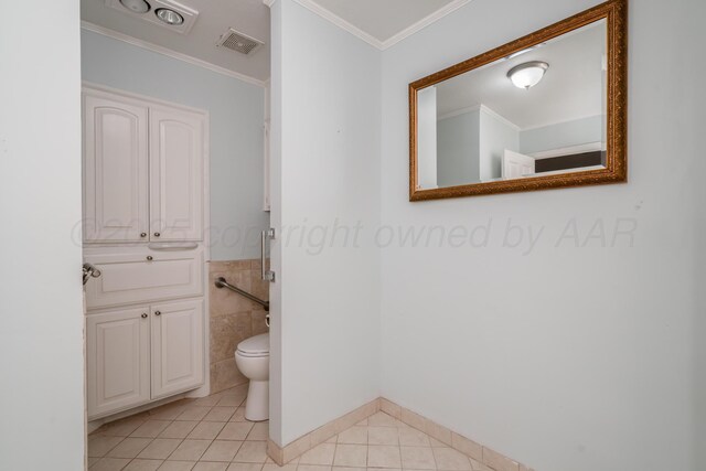 bathroom with visible vents, toilet, ornamental molding, tile patterned floors, and tile walls