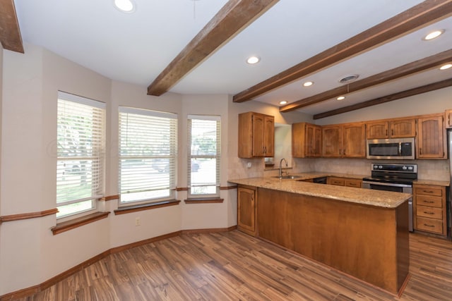5404 While A Way Rd, Amarillo, TX 79109 - kitchen featuring stainless steel appliances, a sink, brown cabinets, tasteful backsplash, and plenty of natural light