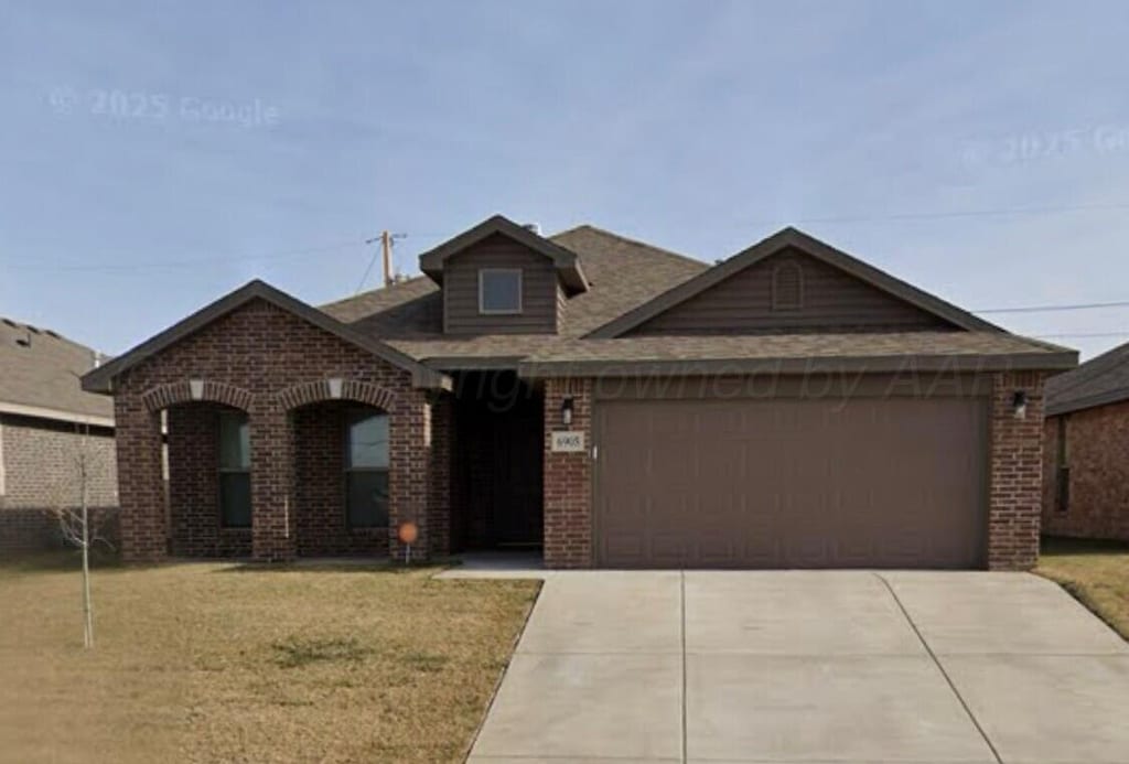 view of front of home featuring a garage, a front lawn, roof with shingles, brick siding, and concrete driveway