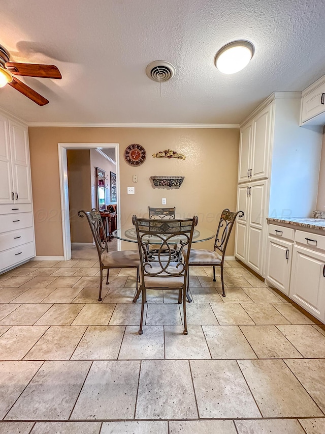 dining room featuring ceiling fan, crown molding, and a textured ceiling