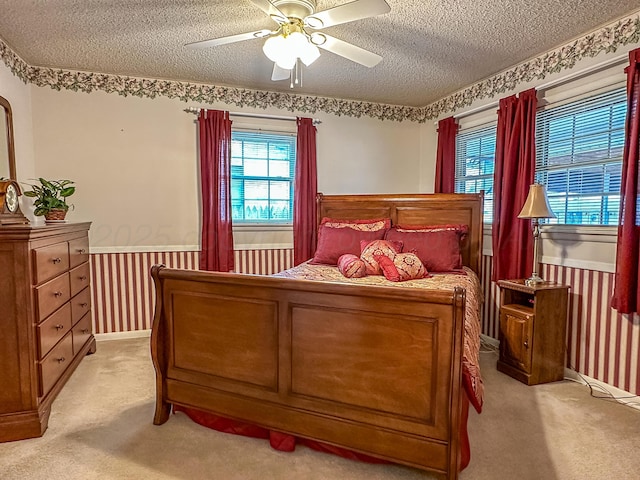 carpeted bedroom with ceiling fan and a textured ceiling