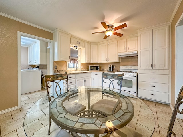 kitchen with white gas range, sink, white cabinets, ornamental molding, and ceiling fan