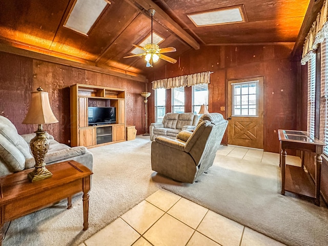 carpeted living room featuring ceiling fan, lofted ceiling with beams, wooden ceiling, and wood walls