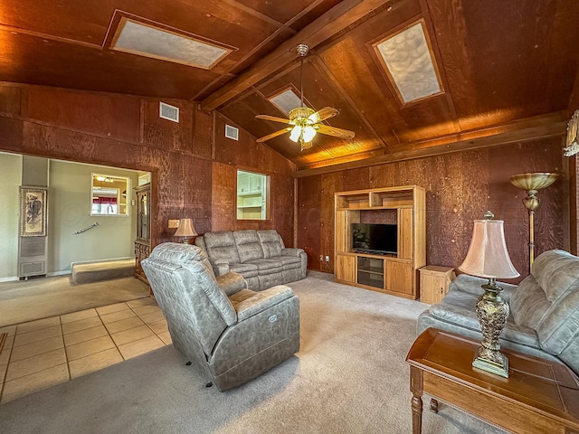 carpeted living room featuring wood ceiling, ceiling fan, lofted ceiling with beams, and wood walls