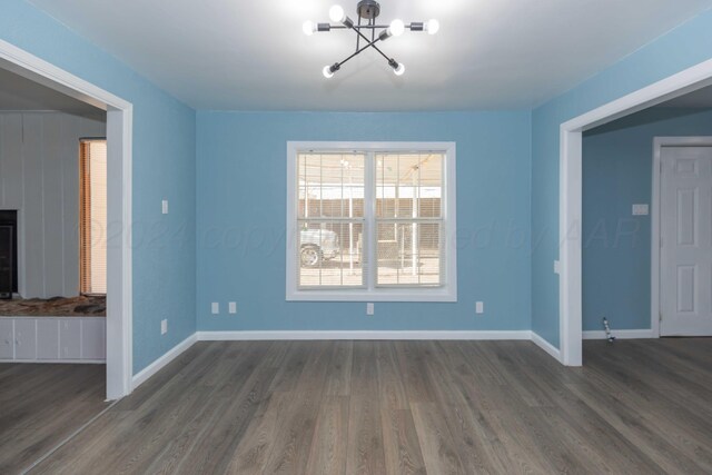 unfurnished dining area with dark hardwood / wood-style flooring and a chandelier