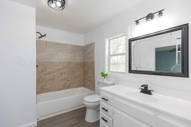 full bathroom with toilet, vanity, tiled shower / bath, and hardwood / wood-style floors