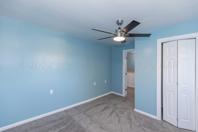 unfurnished bedroom featuring light colored carpet, ceiling fan, and a closet