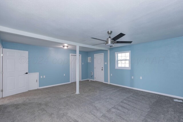 basement with ceiling fan, a textured ceiling, and carpet flooring