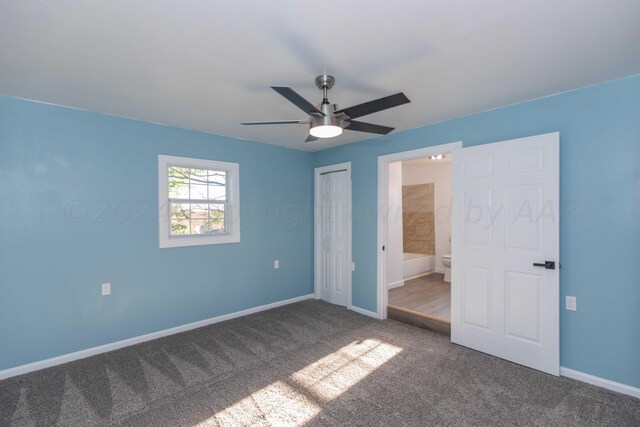 unfurnished bedroom with a closet, ensuite bath, ceiling fan, and carpet floors