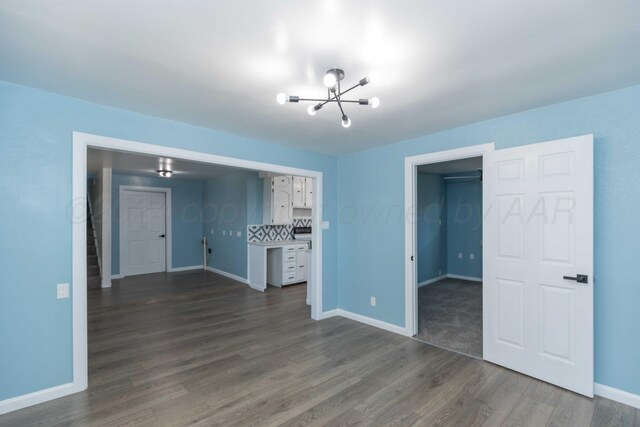 interior space with dark wood-type flooring and a notable chandelier