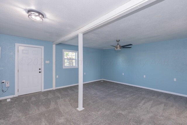 carpeted entryway featuring ceiling fan, beamed ceiling, and a textured ceiling