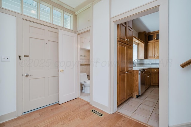 2523 5th Ave, Canyon, TX 79015 - interior space with stainless steel dishwasher, light countertops, light wood-style floors, brown cabinets, and decorative backsplash