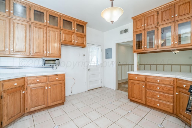 2523 5th Ave, Canyon, TX 79015 - kitchen featuring brown cabinetry, electric panel, tile countertops, and decorative light fixtures
