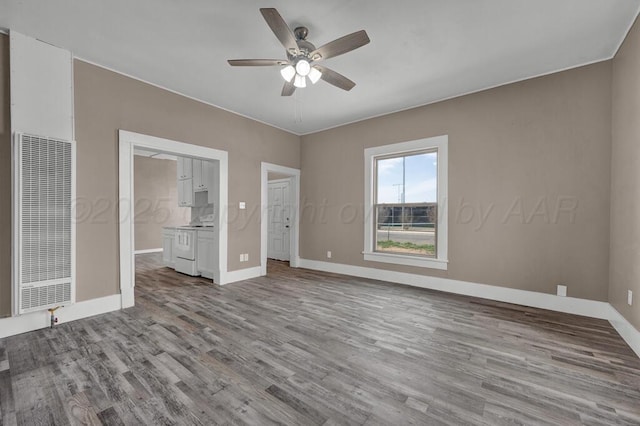 1610 N Hayes St, Amarillo, TX 79107 - unfurnished bedroom with a heating unit, a ceiling fan, wood finished floors, and baseboards