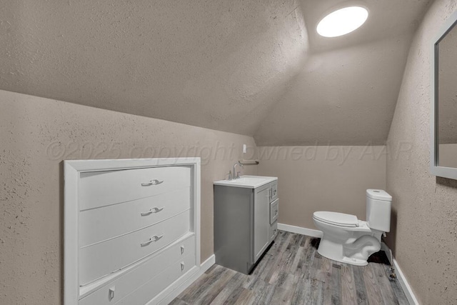1610 N Hayes St, Amarillo, TX 79107 - half bath featuring lofted ceiling, a textured ceiling, toilet, vanity, and wood finished floors
