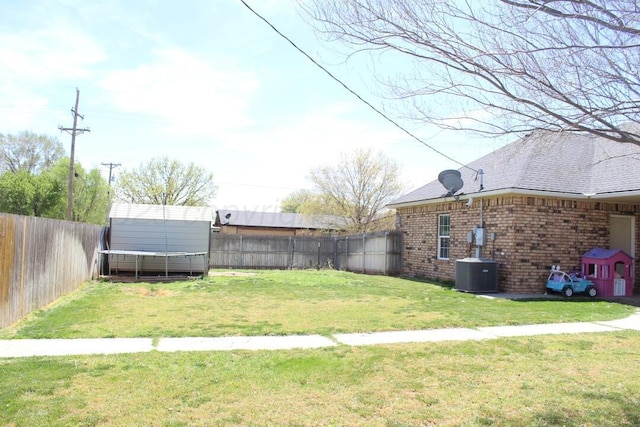 view of yard featuring a fenced backyard, central AC unit, an outdoor structure, and a storage shed