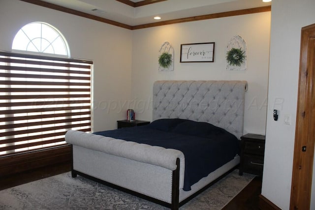 bedroom with wood finished floors, recessed lighting, a raised ceiling, and ornamental molding
