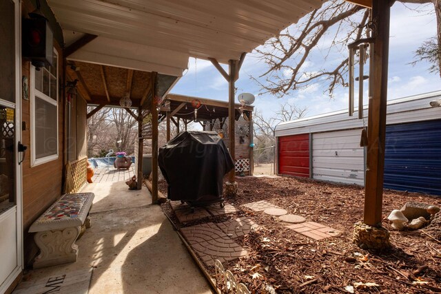 view of patio / terrace featuring an outbuilding, a garage, and grilling area