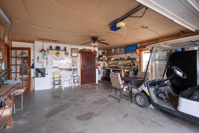 garage featuring a garage door opener, a workshop area, and ceiling fan