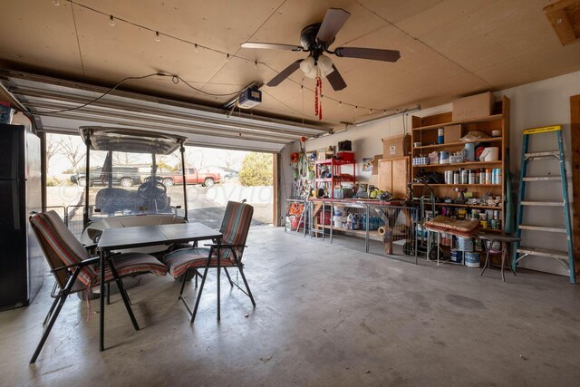 garage featuring a garage door opener, black fridge, and ceiling fan