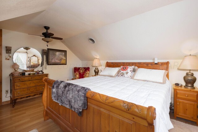 bedroom featuring light hardwood / wood-style floors, ceiling fan, and vaulted ceiling