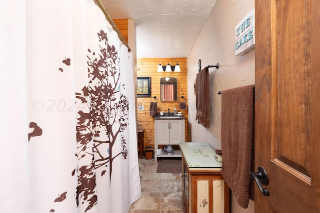 bathroom featuring vanity and wooden walls